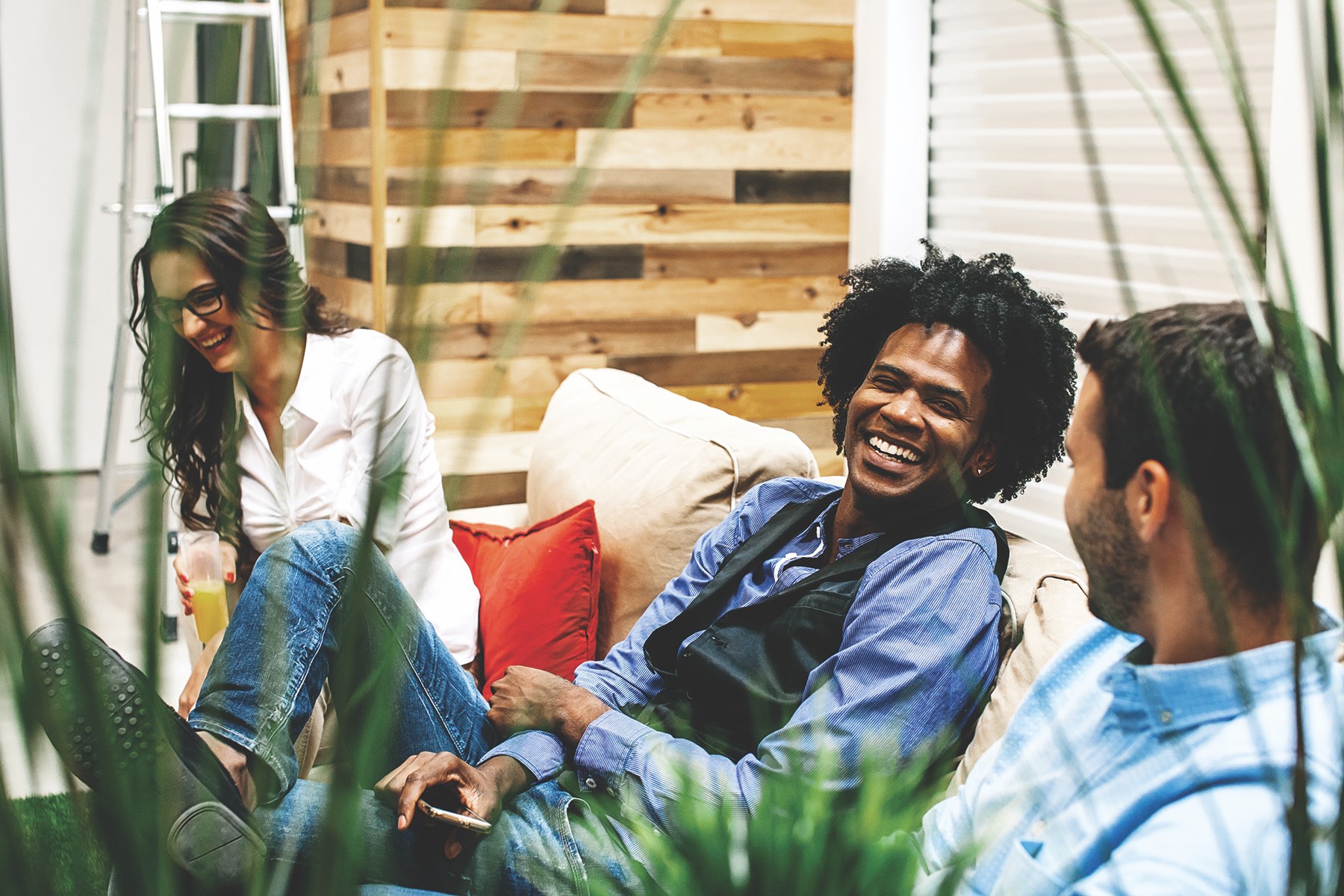 Three friends enjoying each other's company on a cozy couch.